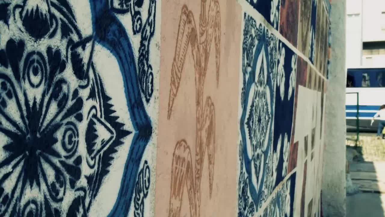 Representative artwork by Add Fuel: a close, angled view of blue and pale pink tile-inspired stencil patterns on the Tem Sempre Encanto mural in Coimbra.